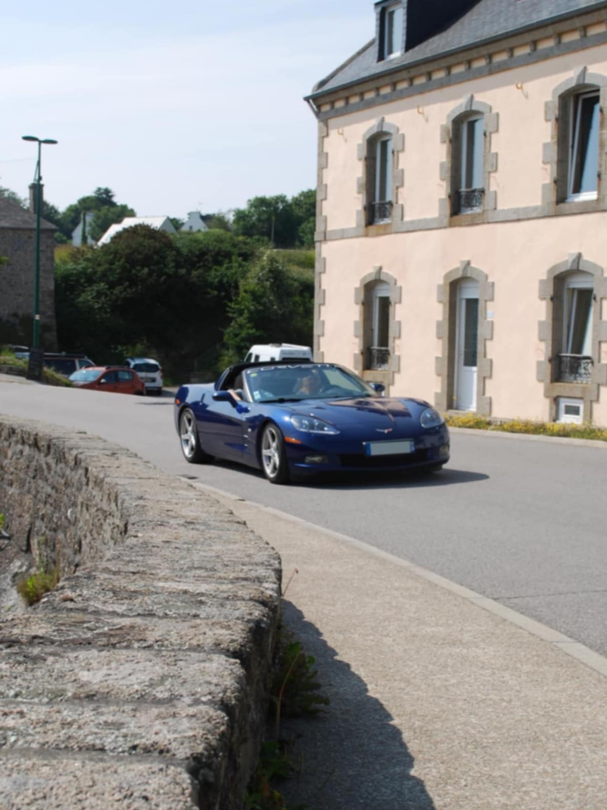 Gros plan sur un détail chromé d'une voiture avec reflets du paysage breton